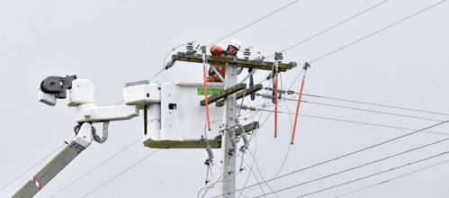 Heroes in orange: working to restore power at Tuapeka Mouth yesterday. Photo: Peter McIntosh, ODT